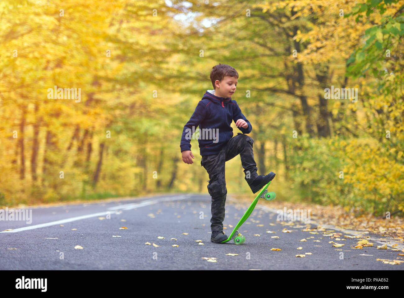 Chico skater haciendo skateboard trucos en otoño de medio ambiente Foto de stock