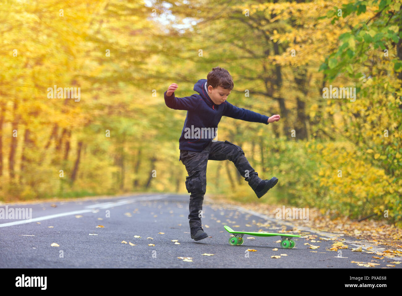 Chico skater haciendo skateboard trucos en otoño de medio ambiente Foto de stock