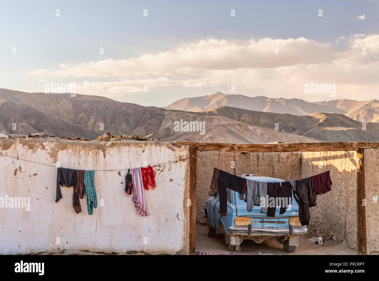 Casa encaladas y coche en luz del atardecer en la aldea, Bulunkul Bulunkul, el Pamir Highway, Gorno Badakhshan, Tayikistán Foto de stock