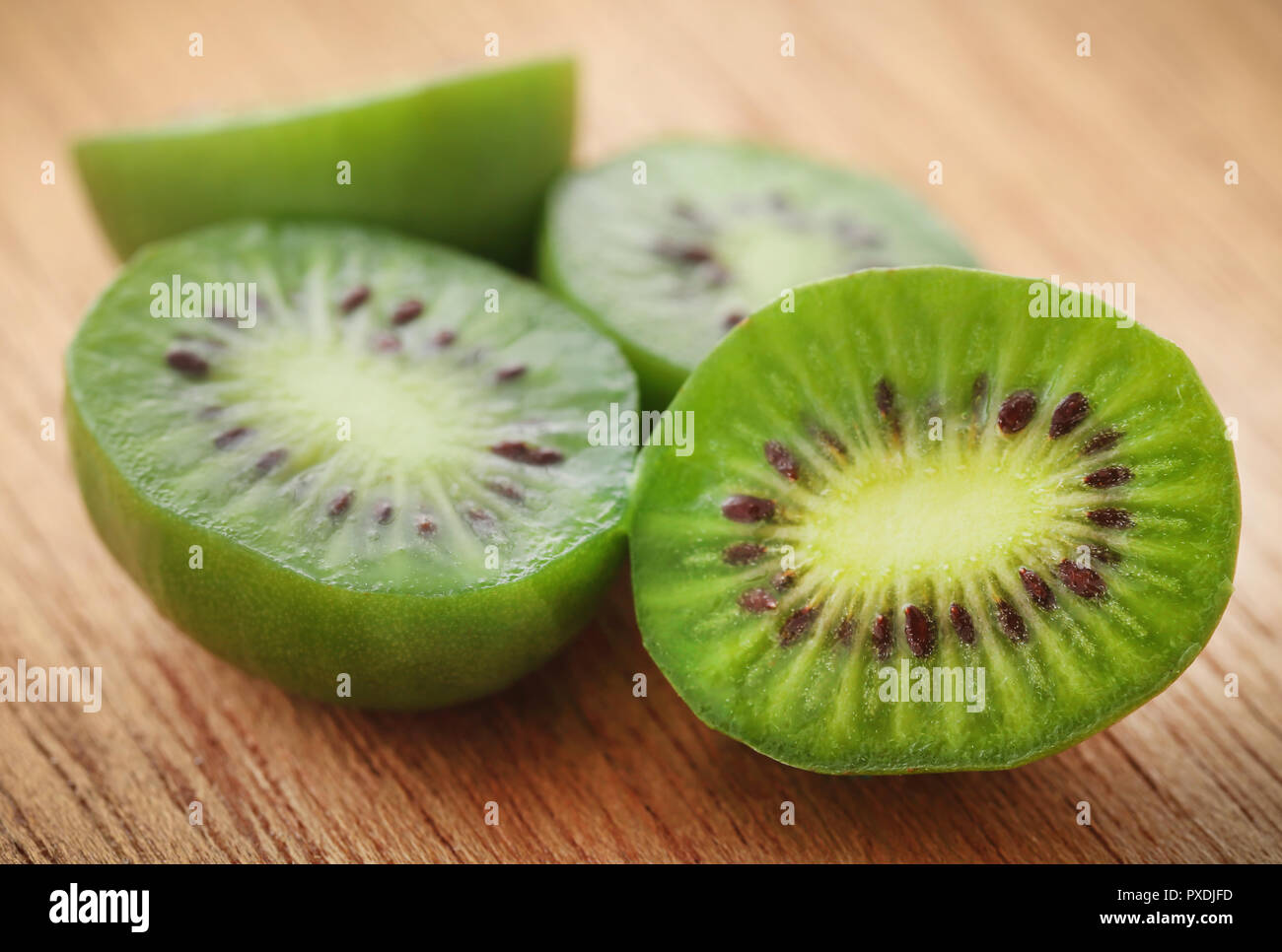 Baby kiwi o Kiwi berry sobre la superficie natural Foto de stock