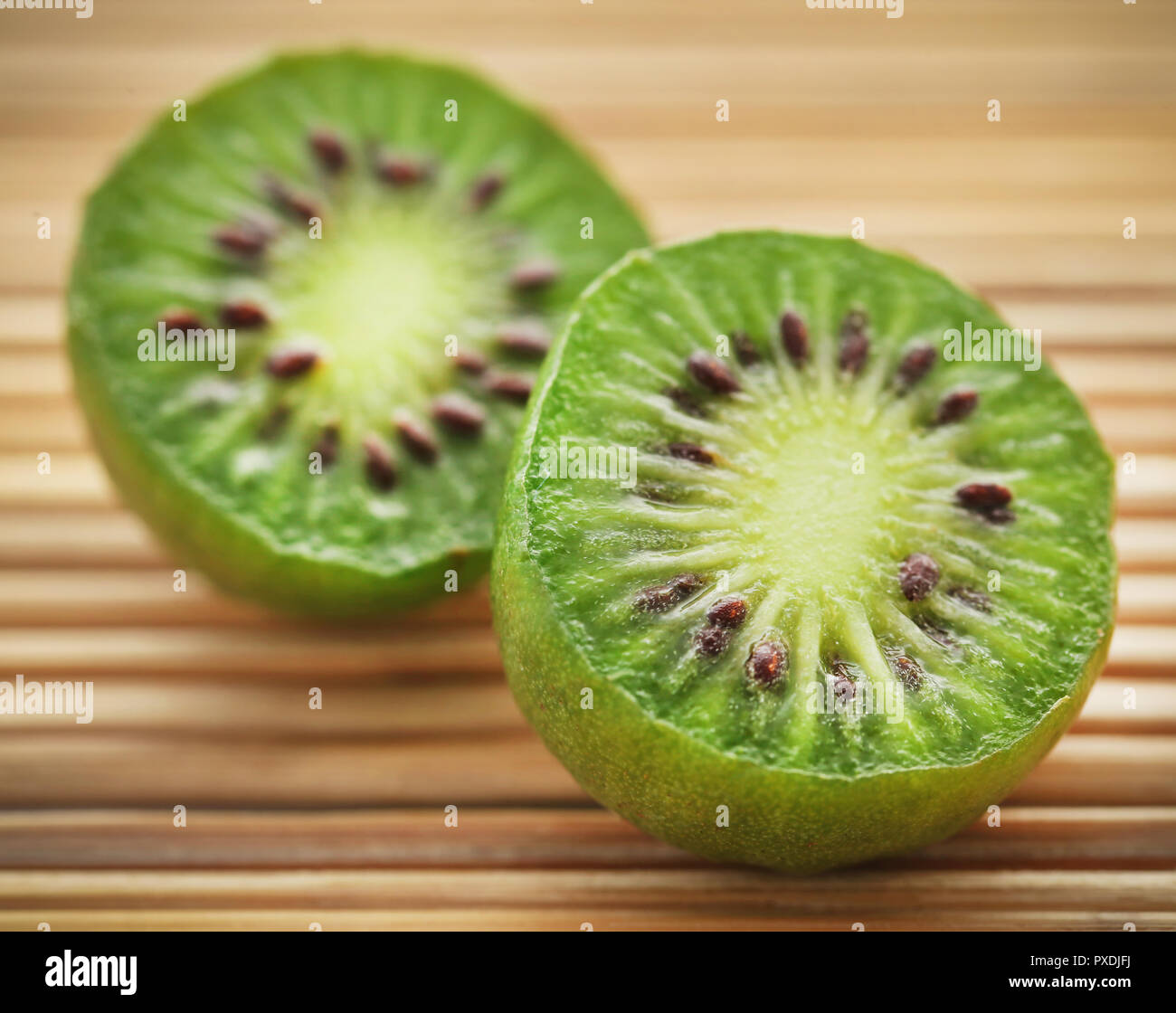 Baby kiwi o Kiwi berry sobre la superficie natural Foto de stock