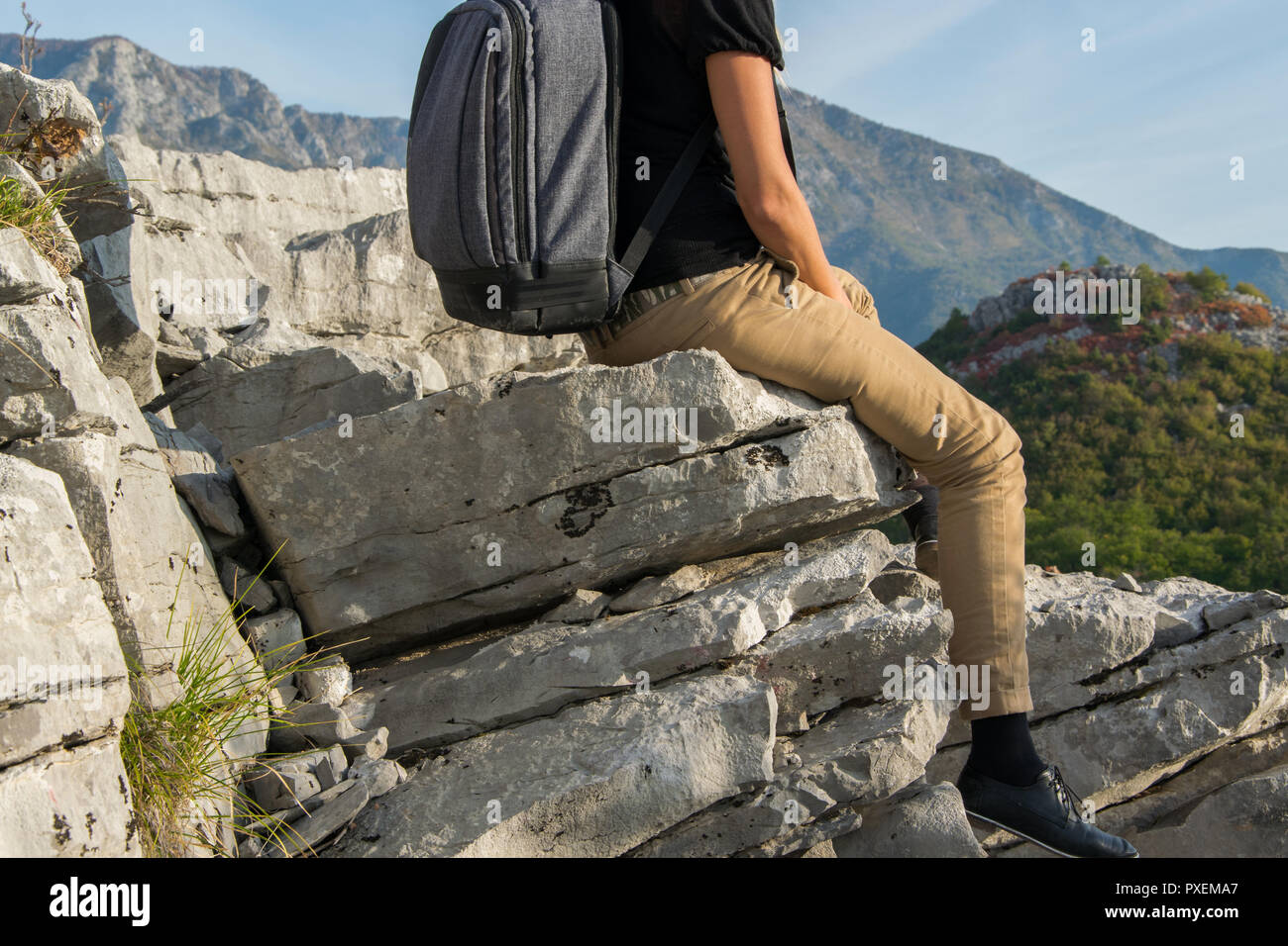 Mujer joven con mochila sentada en el borde de la montaña acantilado contra  hermosas montañas pico. Concepto de estilo de vida y viajes Fotografía de  stock - Alamy