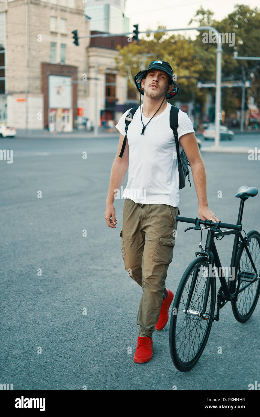 Elegante Hombre con bicicleta para ir a trabajar en la calle. Retrato de jóvenes varones ropa casual con caminando por calles de la ciudad con elegantes bicicleta. Rojo Fotografía