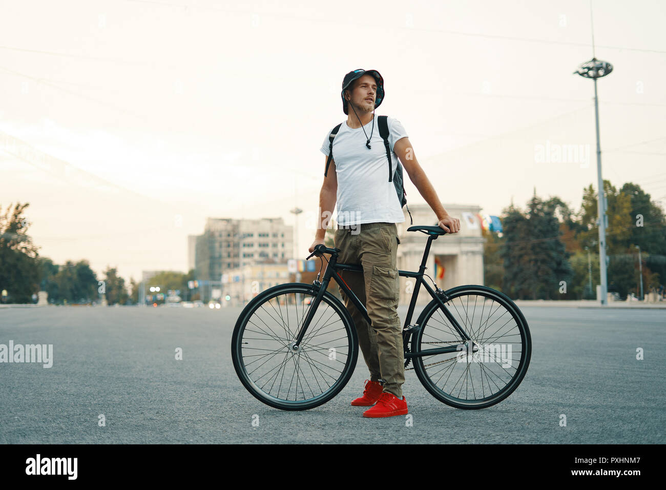 Elegante Hombre con bicicleta para ir a trabajar en la calle. Retrato de  jóvenes varones en ropa casual con mochila caminando por las calles de la  ciudad con elegantes bicicleta. Rojo Fotografía
