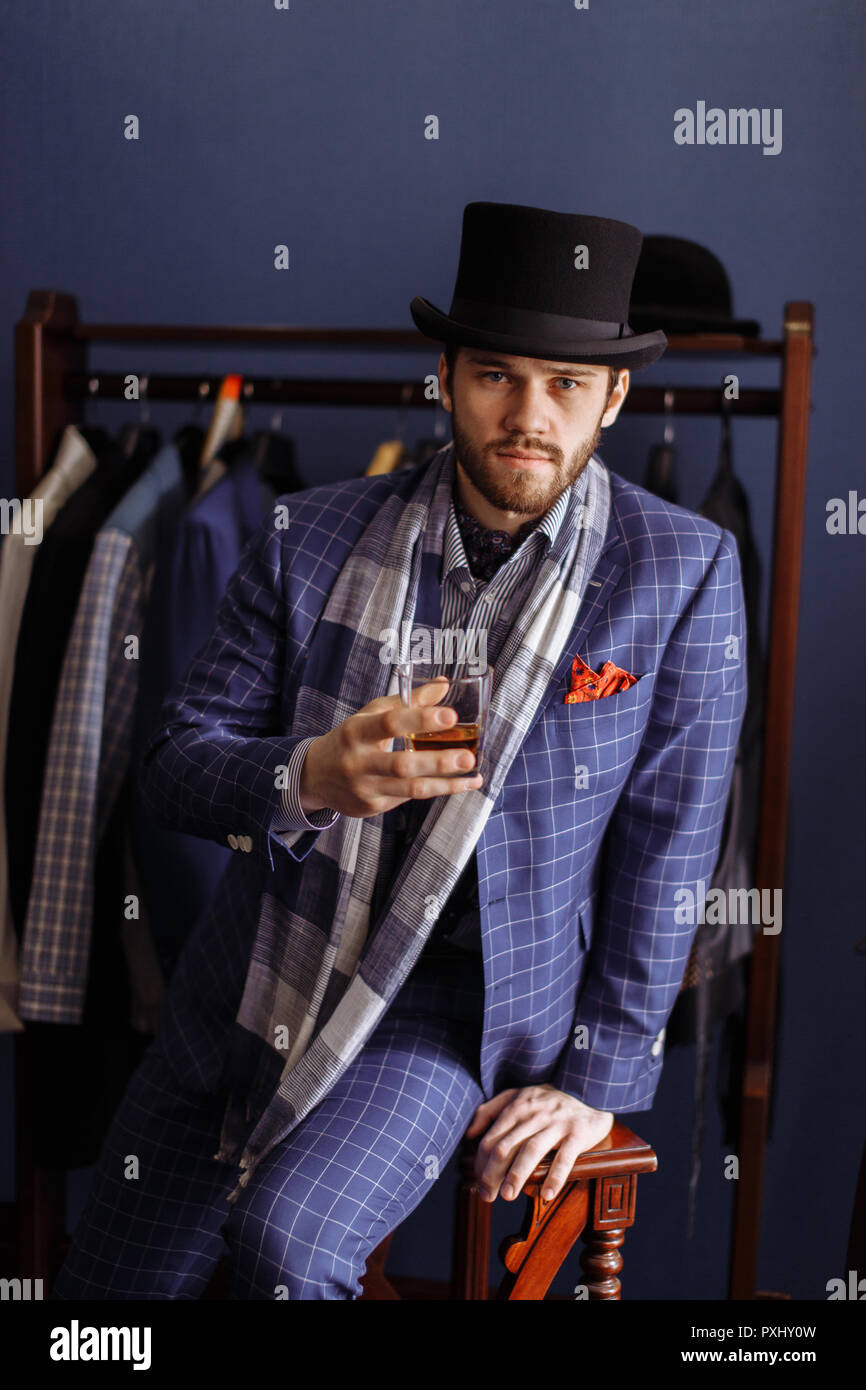 En la moda hombre elegante traje y sombrero posando en atelier con bebidas  Fotografía de stock - Alamy