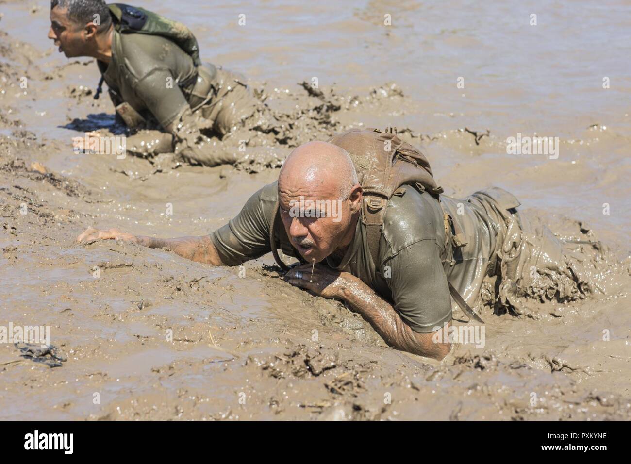 Los marines se arrastran por un lodazal mientras participaba en el 2017  Marine Corps barro ejecutar por el lago O'Neill a bordo de Camp Pendleton,  California, el 9 de junio. La carrera