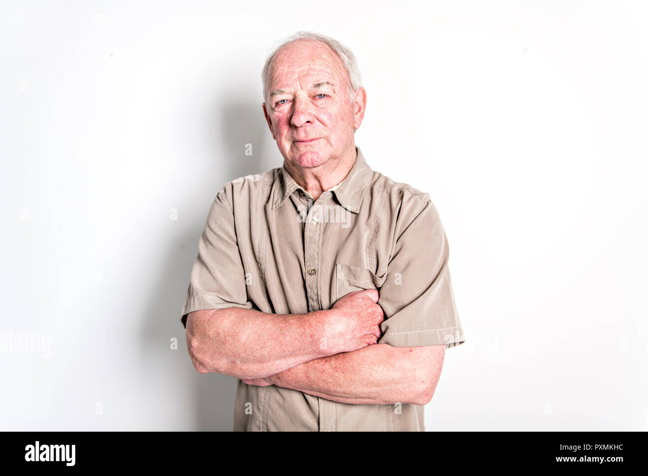 Senior, de 70 años, hombre de pie aislado sobre fondo blanco. Foto de stock