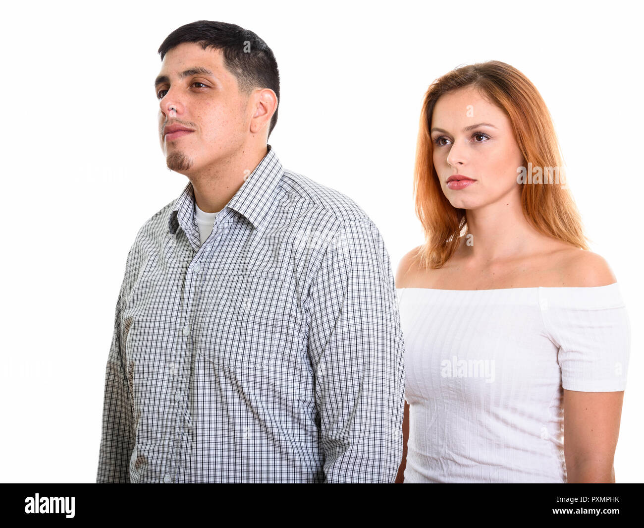 Foto de estudio de pareja joven hispana pensando mientras miraba lejos juntos Foto de stock