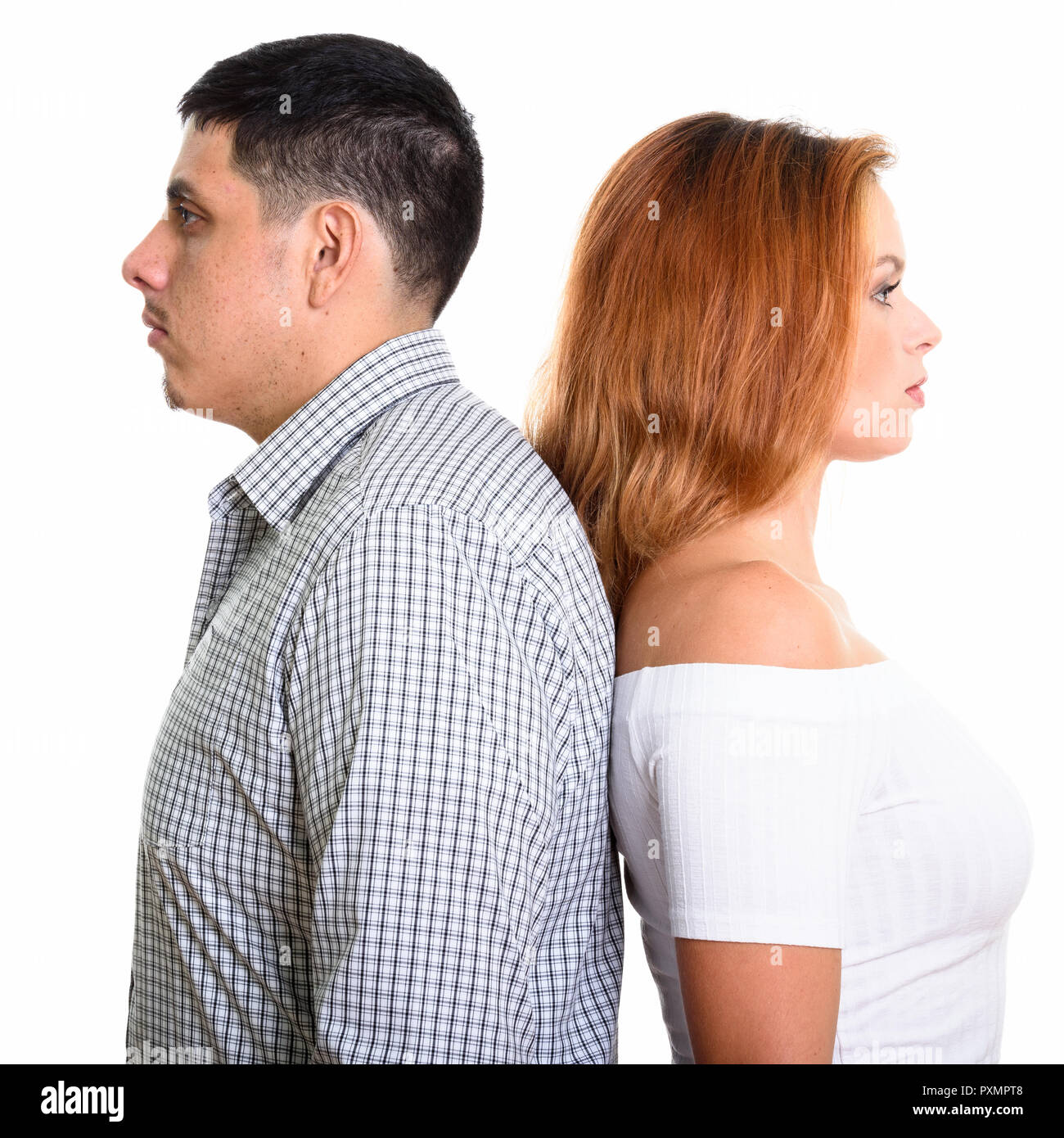 Foto de estudio de pareja joven hispana con espalda contra cada uno de ellos Foto de stock