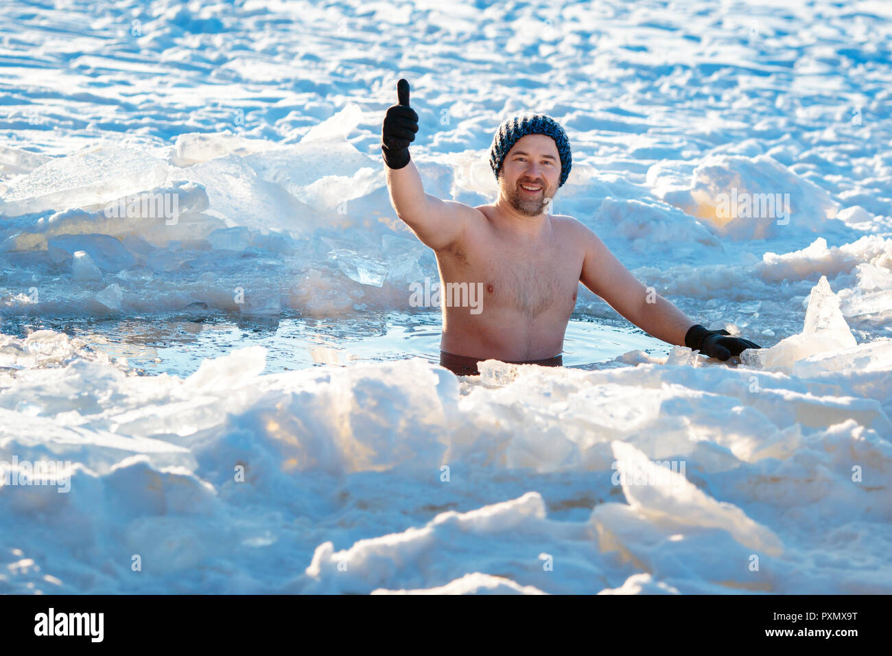 Piscina de Invierno. Hombre valiente en un agujero de hielo. Foto de stock