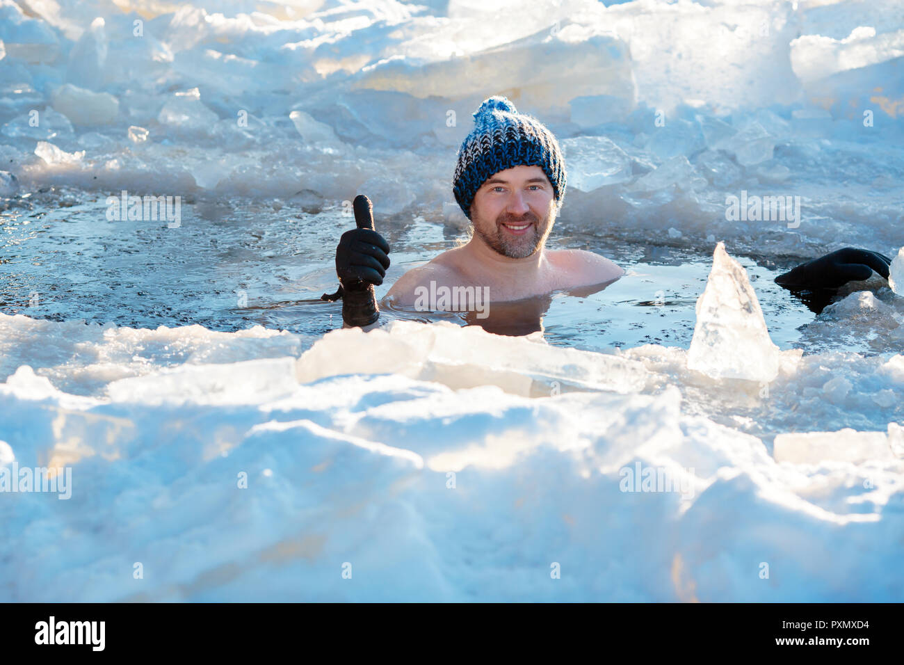 Piscina de Invierno. Hombre valiente en un agujero de hielo. Foto de stock