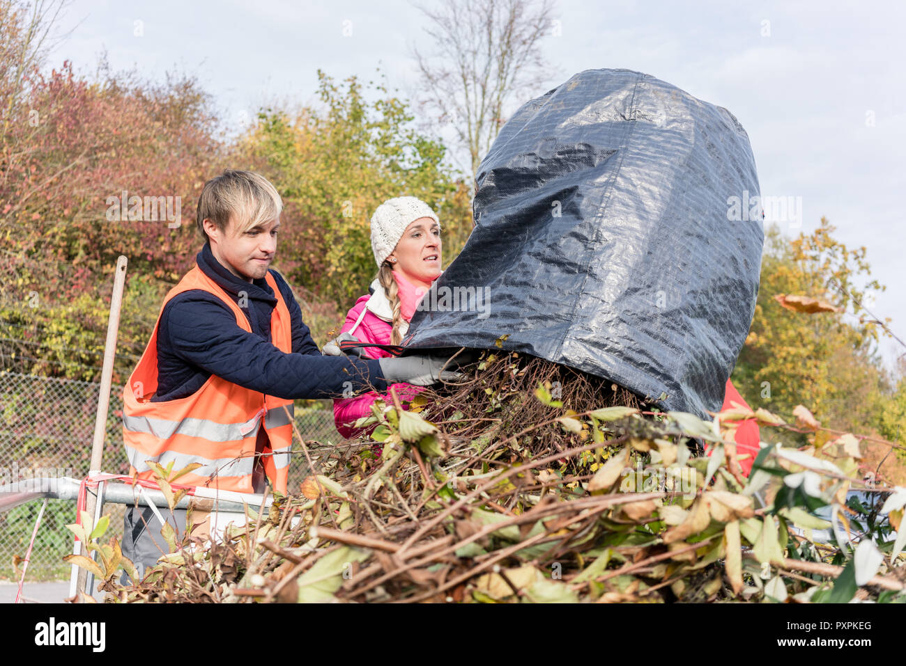 Mujer y hombre de putting green en el contenedor de residuos Foto de stock