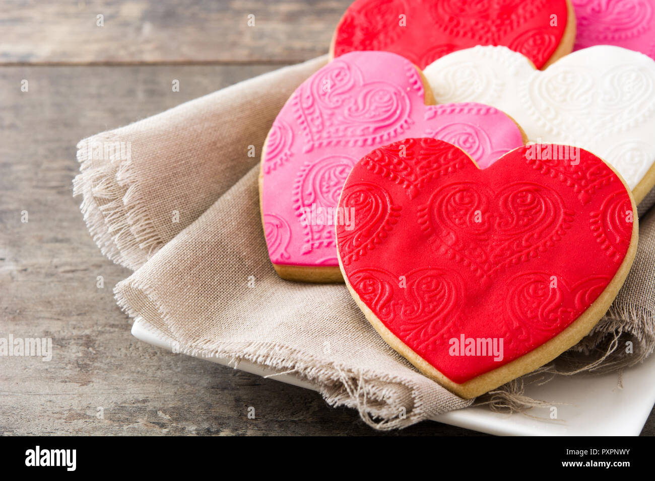 Las galletas con forma de corazón para el Día de San Valentín en mesa de madera Foto de stock