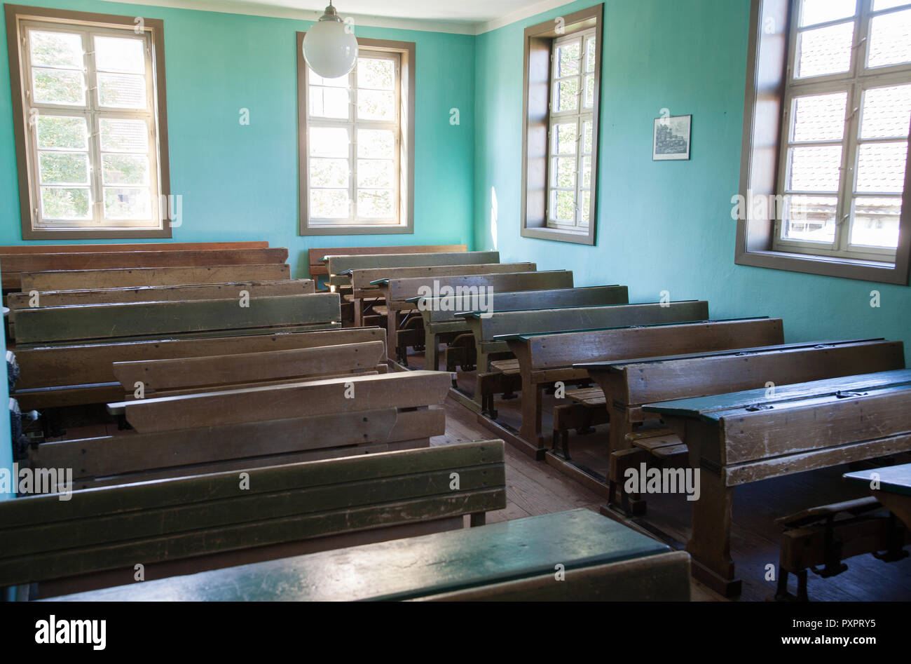 Aula con antiguos pupitres y asientos de madera vacías Foto de stock