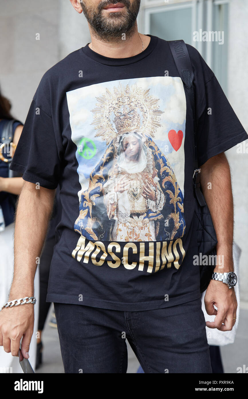 Milán, Italia - 22 de septiembre de 2018: el hombre de negro camisa  Moschino con María Santísima antes de la filosofía de diseño de moda,  Street Style de la Semana de la