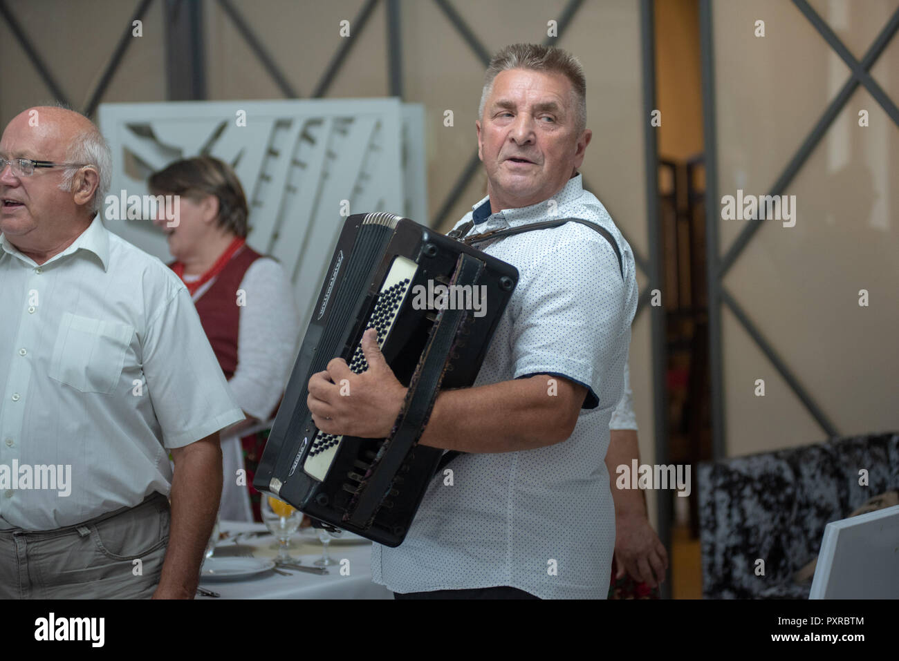 Senior masculino adulto obtiene listo para jugar su acordeón, Zwoleń, Masovian voivodato, Polonia Foto de stock