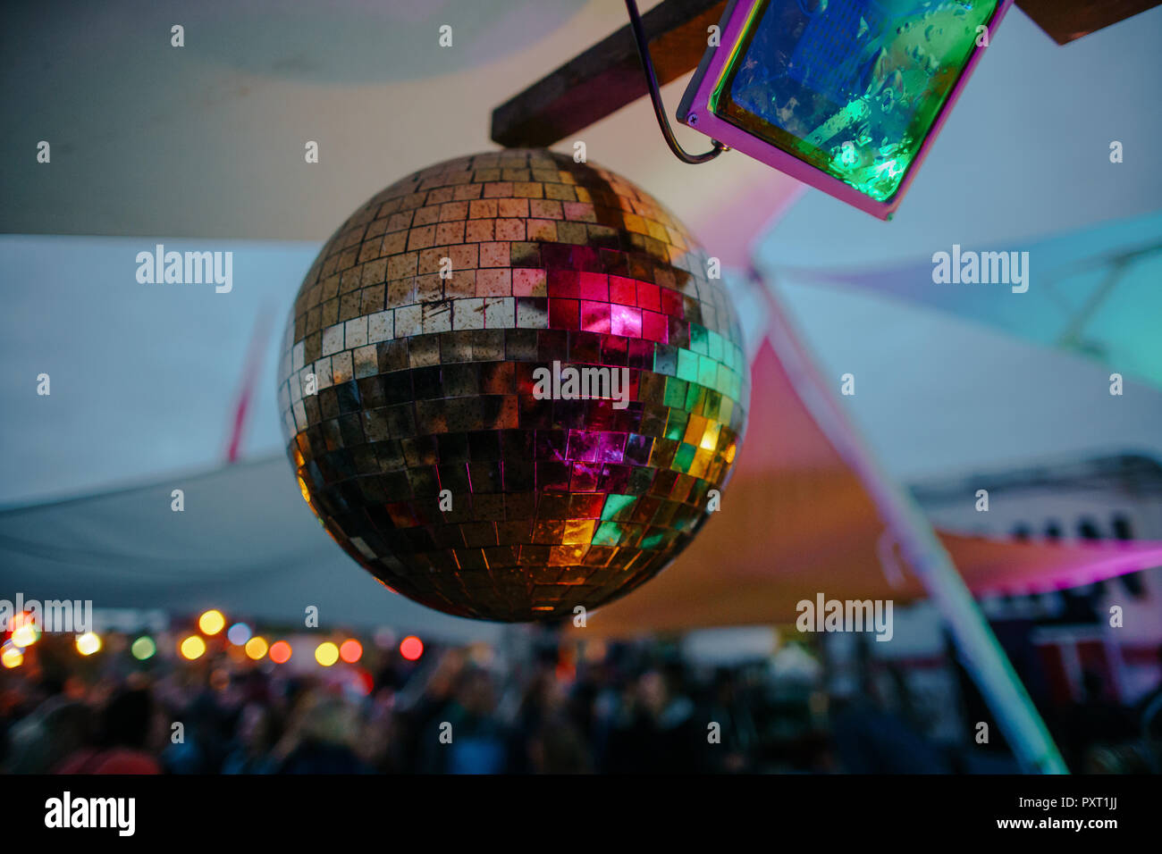 Foto de bola de discoteca con gente incidental en el fondo Foto de stock