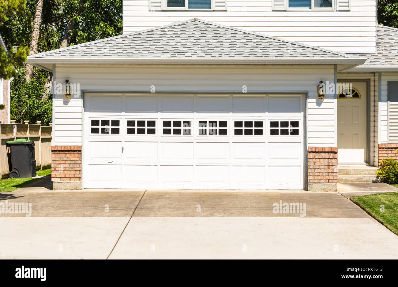 Un perfecto vecindario. Casa unifamiliar con amplio garaje y puerta de  entrada en frente de hormigón Fotografía de stock - Alamy