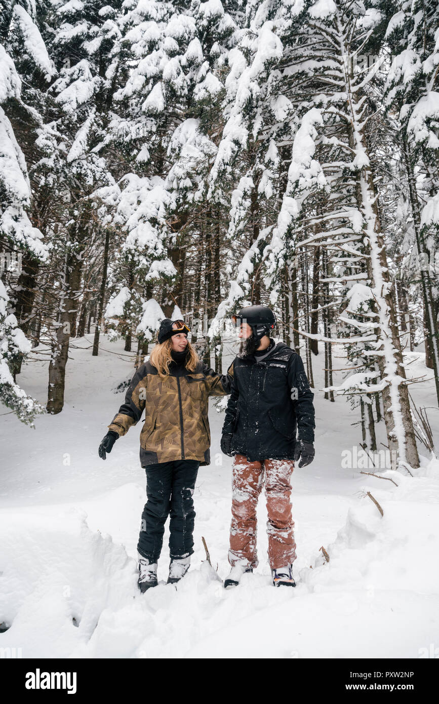 Italia, Módena, Cimone, pareja de esquí en invierno bosque permanente Foto de stock