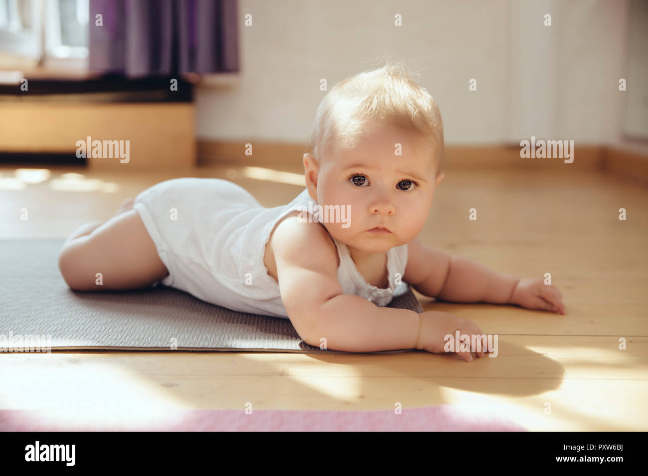 Portait de bebé acostado sobre la estera del yoga Foto de stock