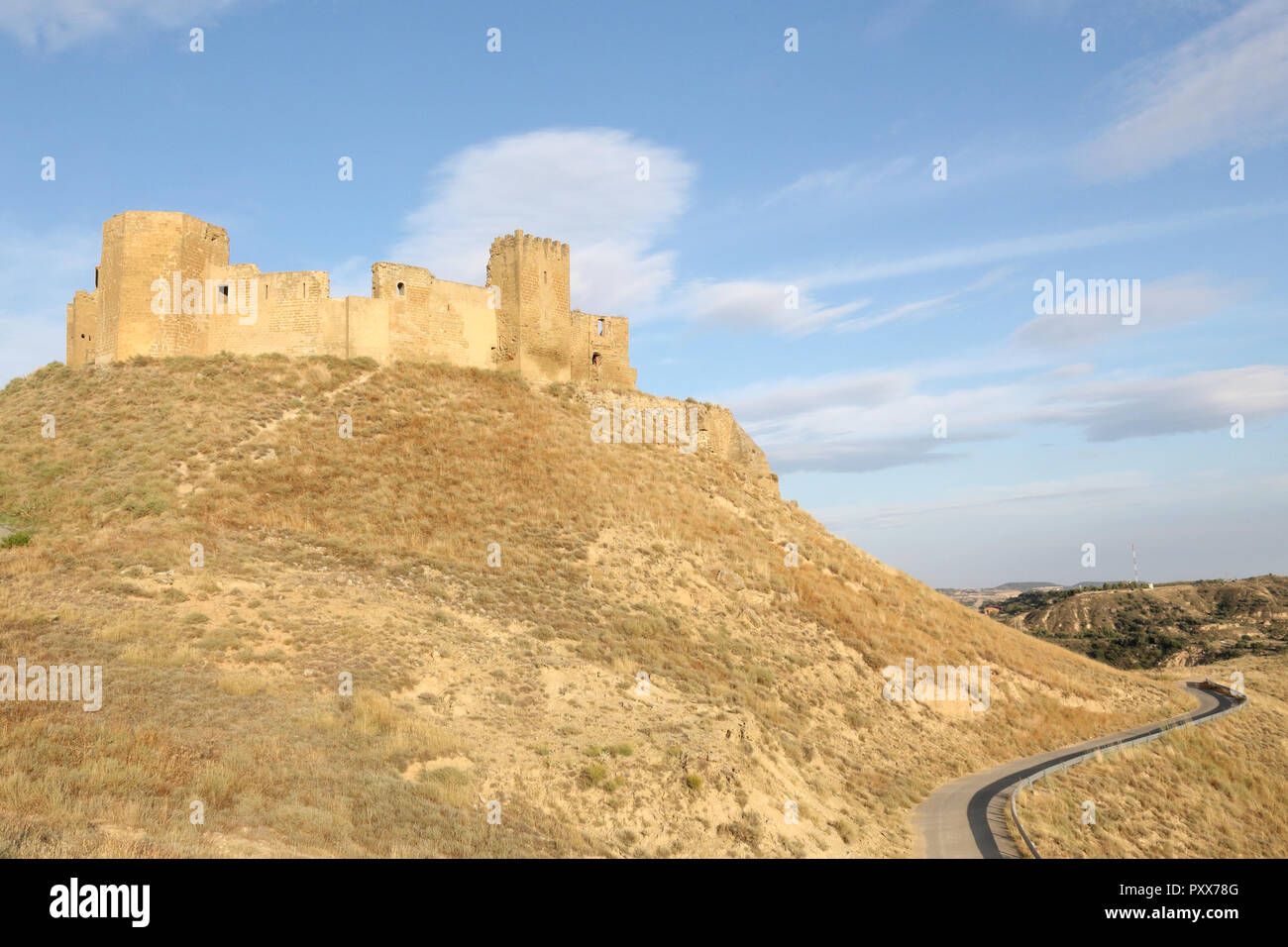 Un paisaje de la medieval abandonado Montearagon castillo, situado sobre una colina, entre campos de cultivo, labrados en una tarde de verano, en la región de Aragón, España Foto de stock