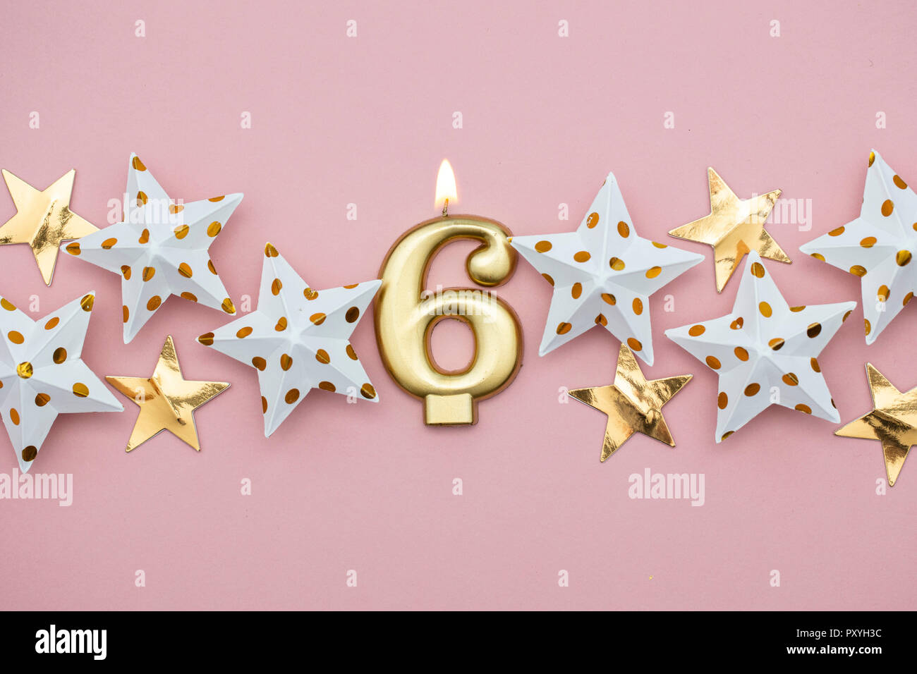 Número 6 velas de oro y estrellas sobre un fondo de color rosa pastel  Fotografía de stock - Alamy