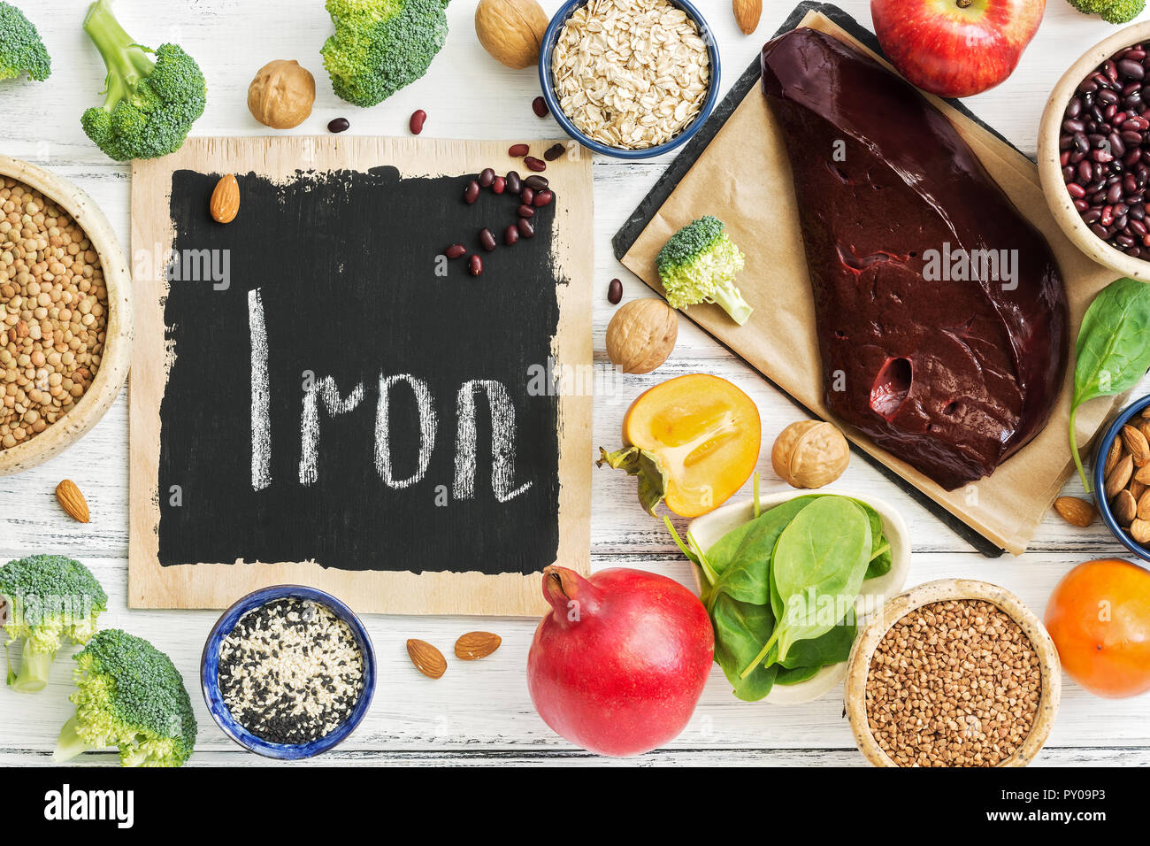 Alimentos ricos en hierro, las frutas, las verduras, el hígado sobre una  tabla de madera blanca. Vista superior, plano laical. El concepto de la  salud alimentaria y macroelementos Fotografía de stock -