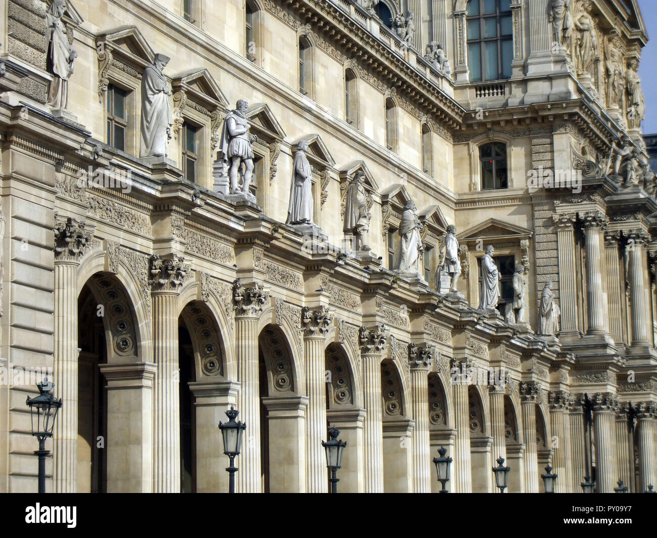 Parte de la Fachada del museo del Louvre mostrando impresionantes detalles arquitectónicos, diseños, estatuas y pilares que ha atraído a miles y miles de turistas, visitantes, turistas y amantes del arte a la creación, en París, cada año. Foto de stock
