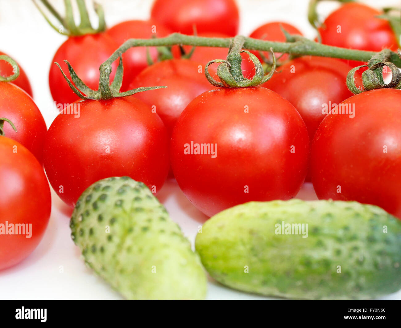 Pepinos y tomates frescos en la placa blanca. Cultivo de hortalizas. Los alimentos naturales Foto de stock