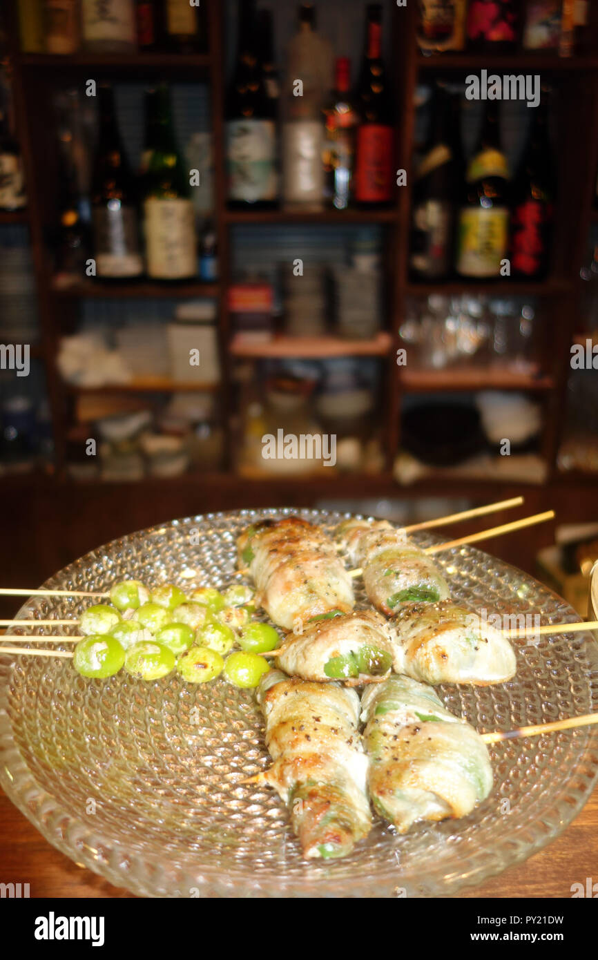 Otoño temporada incluyendo especialidades asadas gingko tuercas y espárragos envueltos en jamón, bar en Asakusa, Tokio, Japón. No hay PR Foto de stock