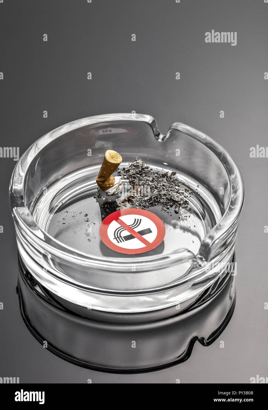 En Aschenbecher ausgedrueckt Zigarette, Verbotszeichen Foto de stock