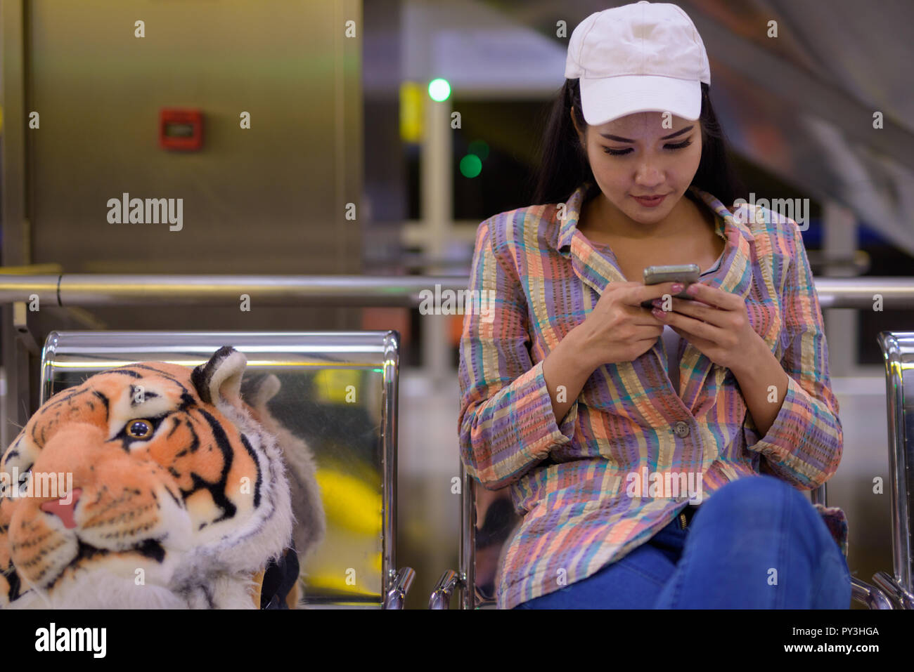 Mujer turismo asiático a través de teléfono móvil en la estación de tren Foto de stock