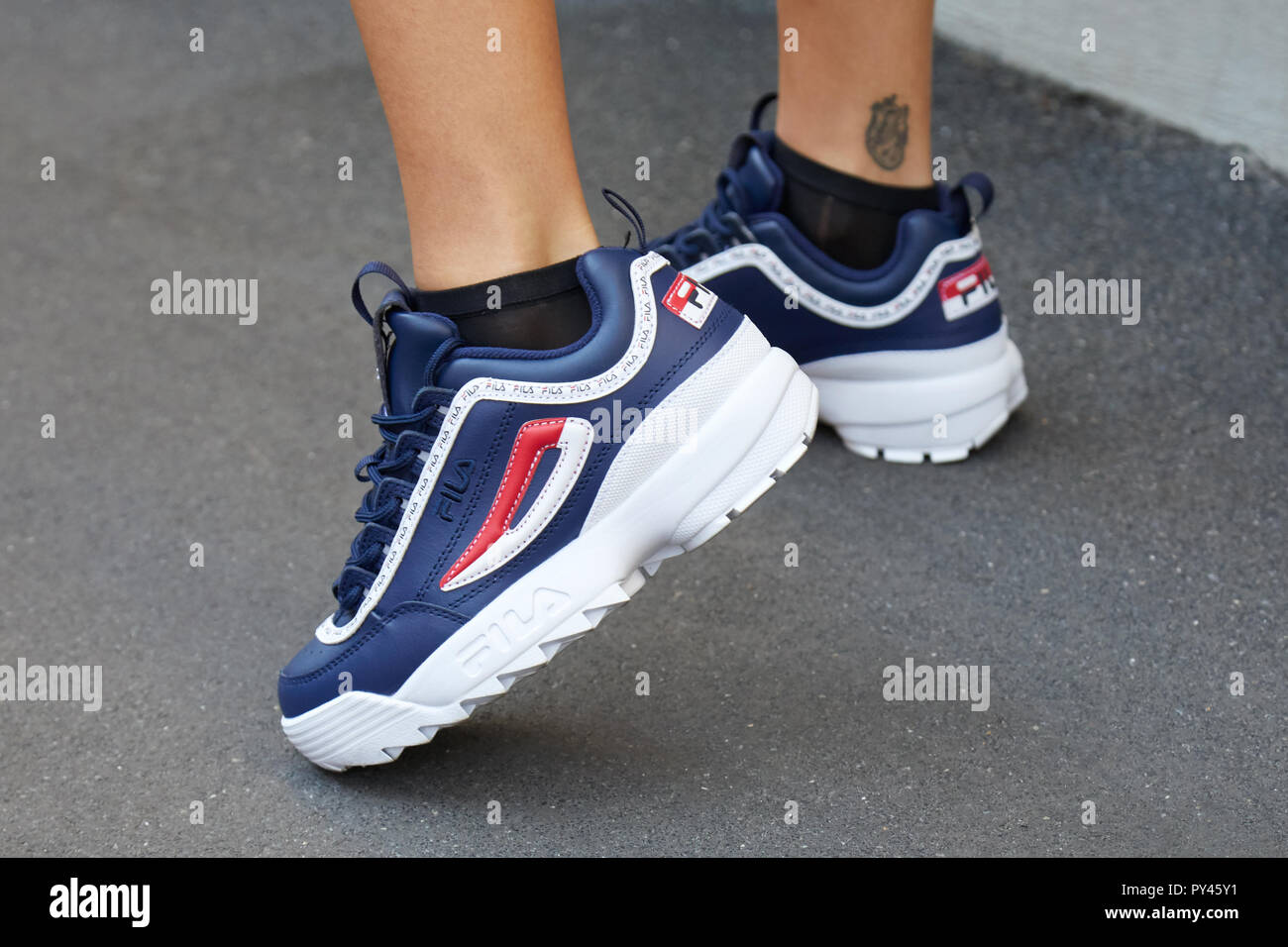 Italia - 23 de septiembre de 2018: Mujer con blanco, azul y rojo zapatillas de Fila Fashion Show, la de la moda de Milán street style Fotografía de stock - Alamy