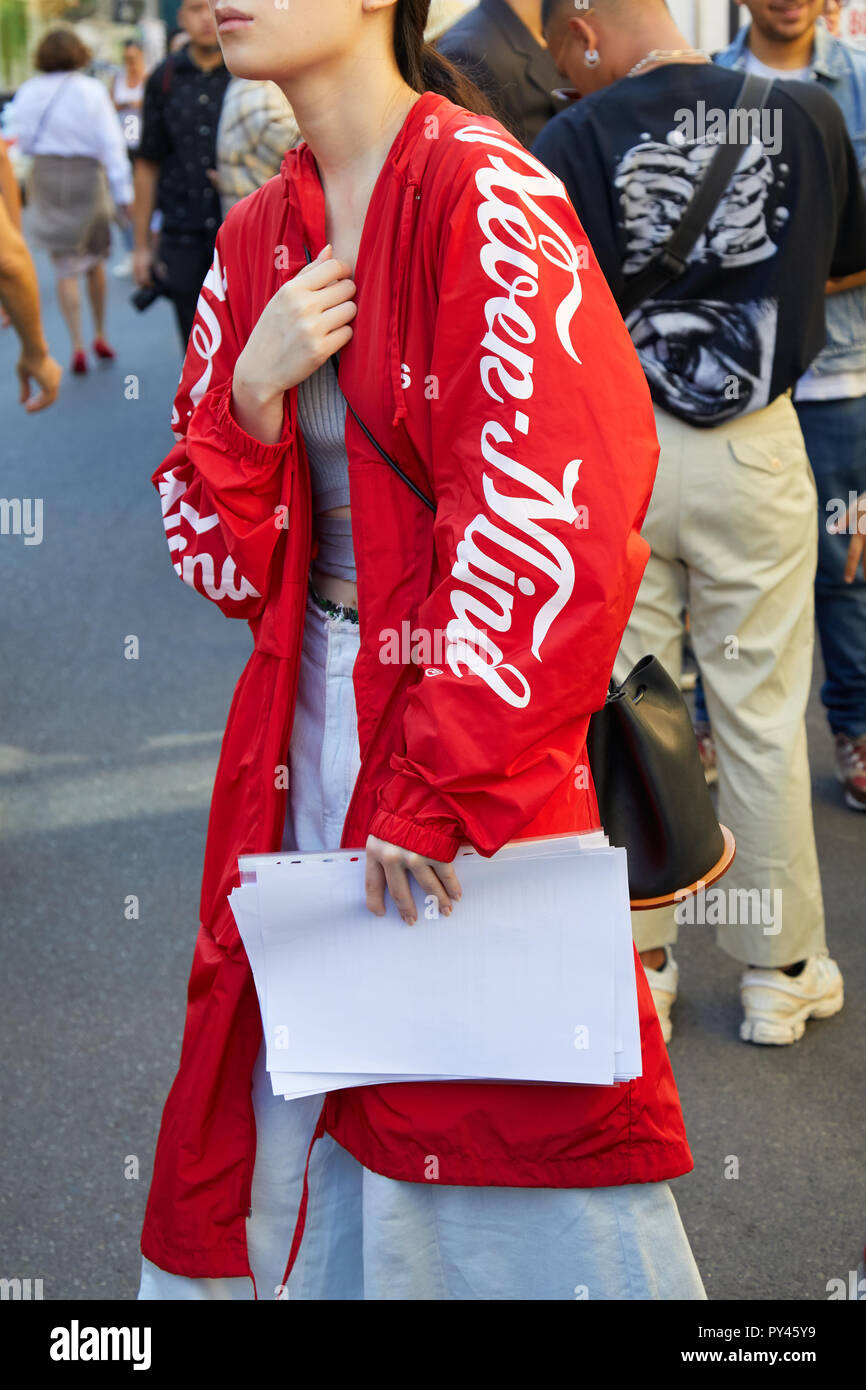 Milán, Italia - 23 de septiembre de 2018: Una mujer con un largo, chaqueta  roja y pantalones blancos antes de Fila Fashion Show, la Semana de la moda  de Milán street style