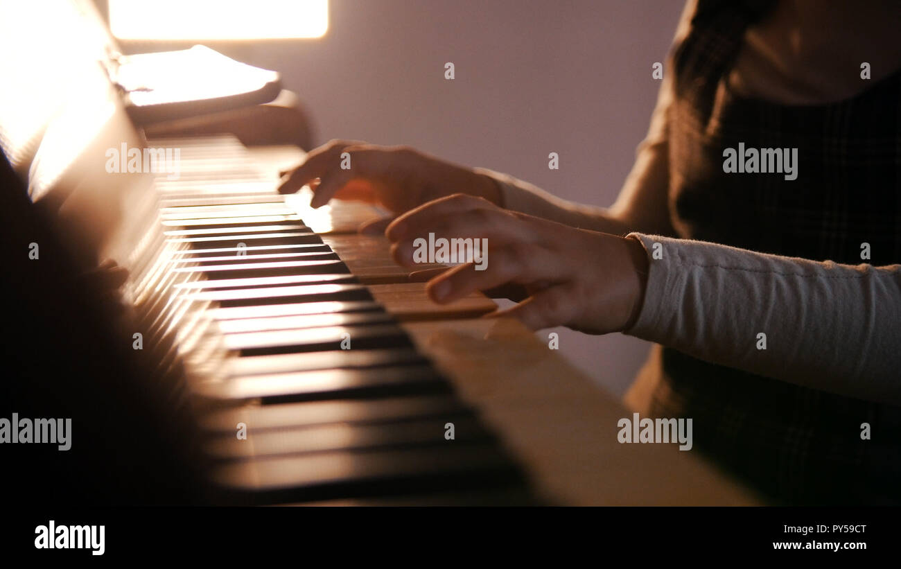 Un bebé tocando el piano en la lección de música. Hermoso sol Foto de stock