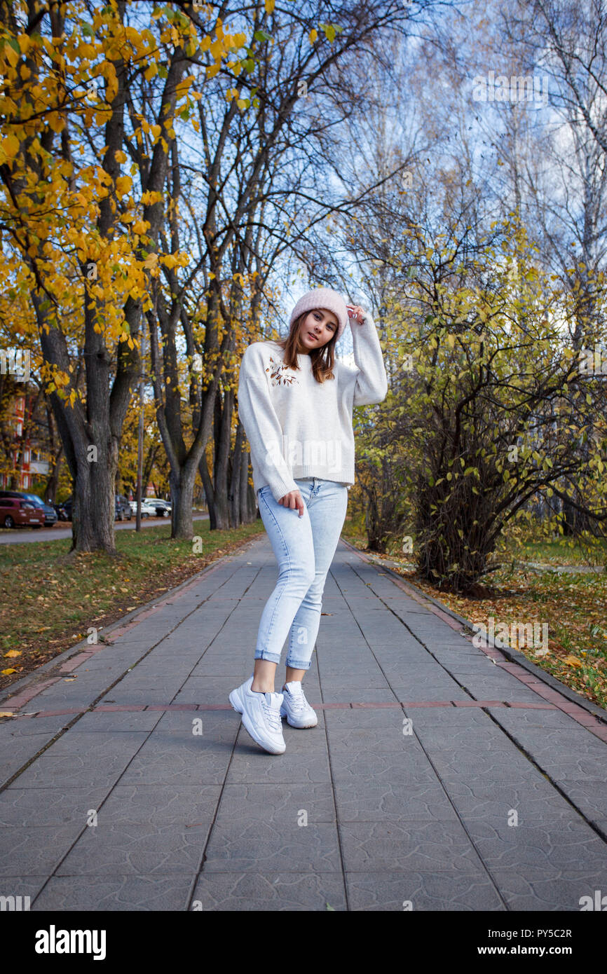Moda joven mujer hipstaer casual ropa de temporada cálida sombrero y pantalones vaqueros azules sobre fondo urbano de otoño. Hipster posando en str Fotografía de stock - Alamy