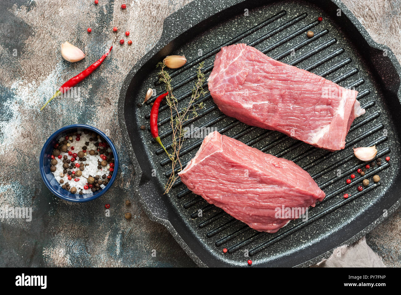 Carne fresca cruda en una parrilla. Dos trozos de carne con especias para cocinar. Vista desde arriba. Foto de stock