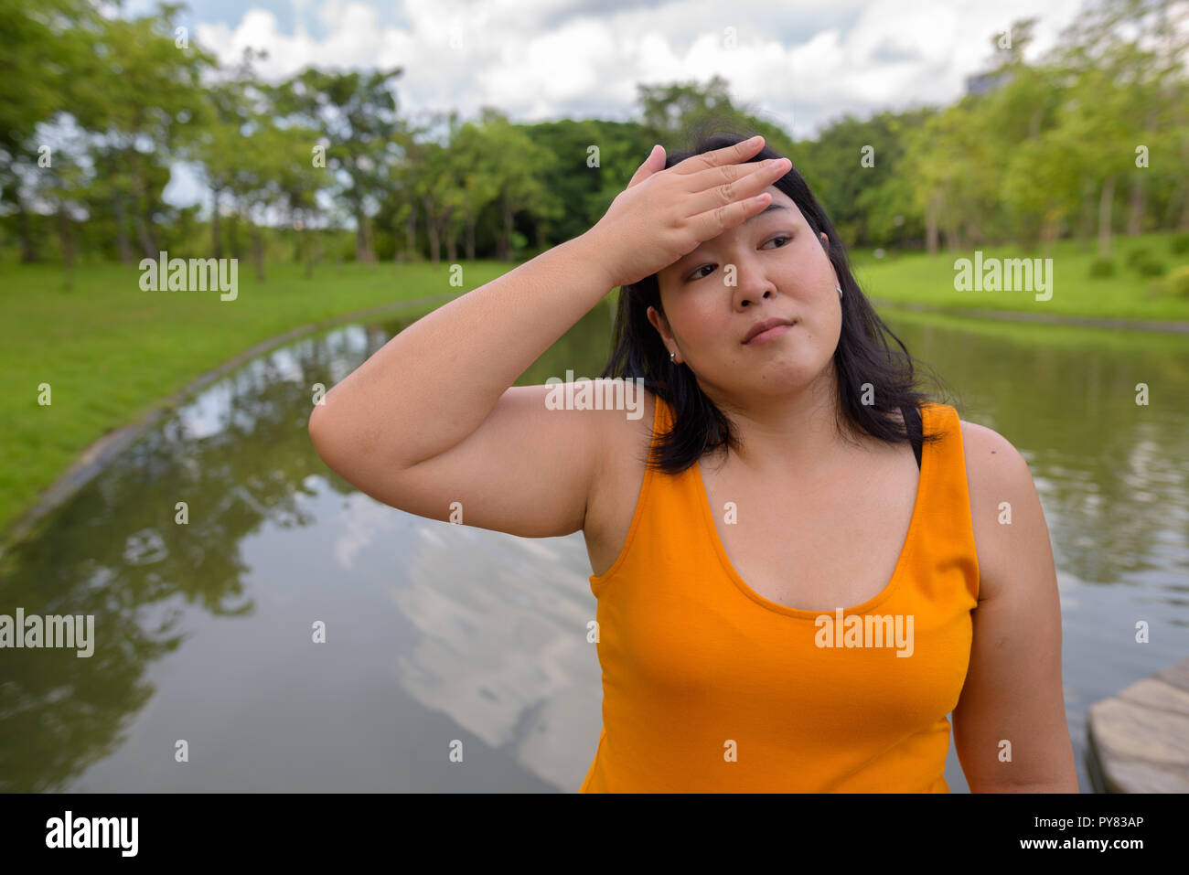 Hermosa mujer asiática con sobrepeso relajante en el parque en el cit Foto de stock