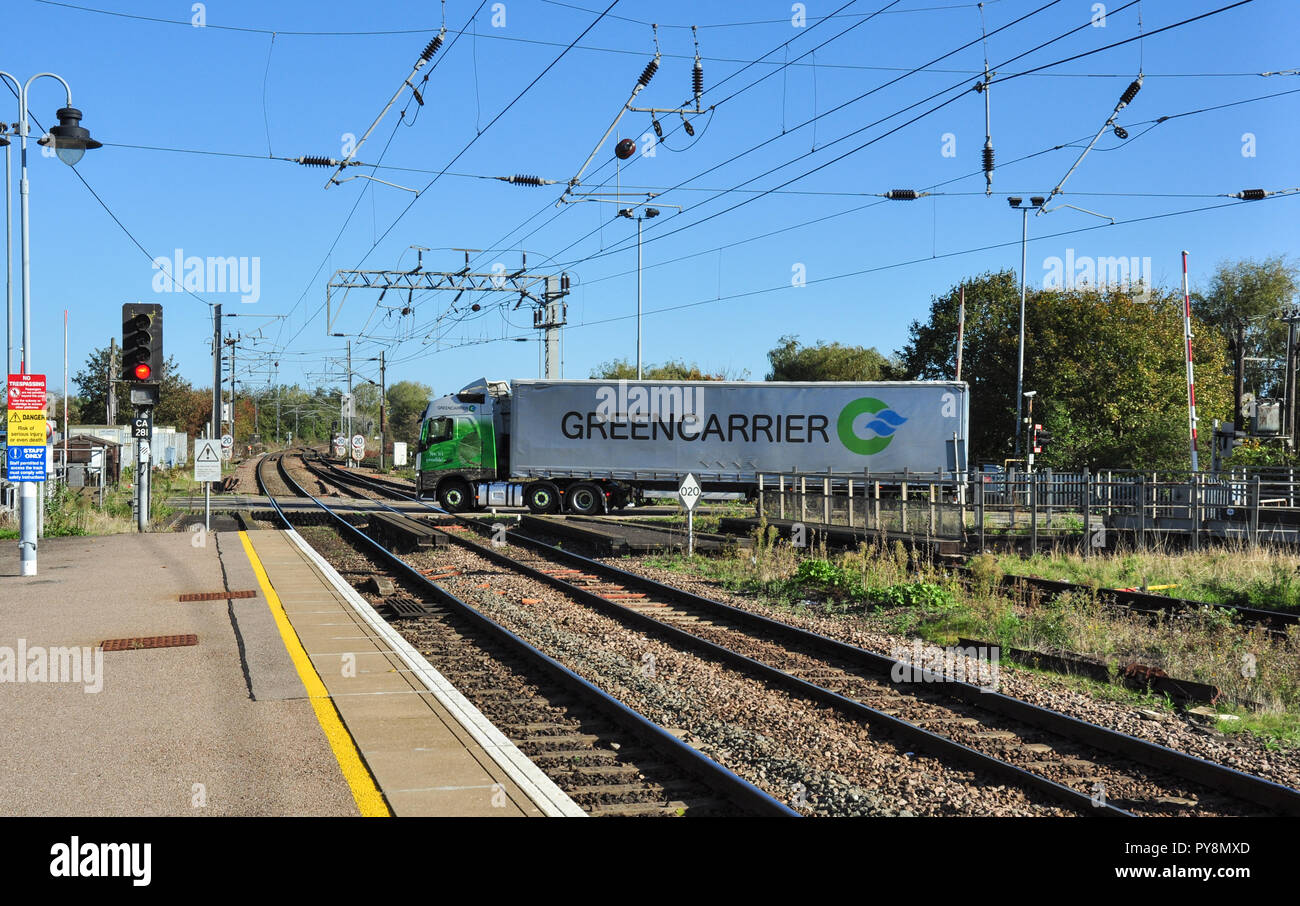 Los vehículos atravesar el paso a nivel en la estación de tren de Ely, Cambridgeshire, Inglaterra, Reino Unido. Foto de stock