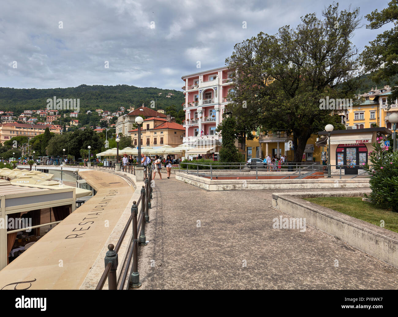 Sendero a lo largo de la playa de la ciudad en el fondo en Opatija, Croacia Foto de stock
