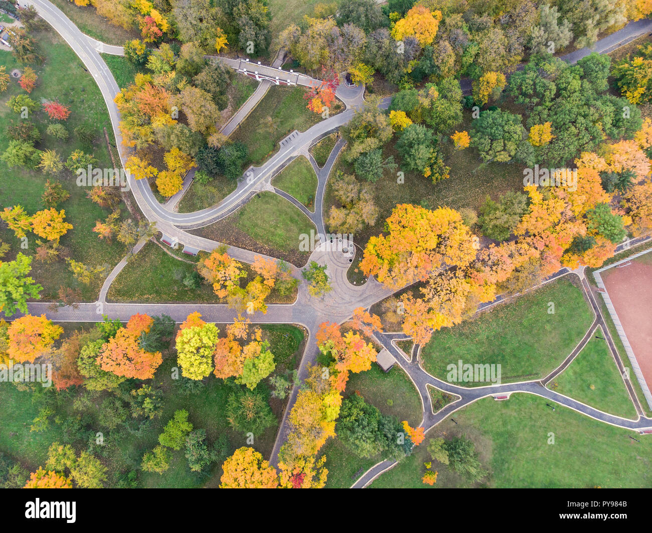 Vista aérea del parque con senderos, árboles amarillos y verdes prados Foto de stock