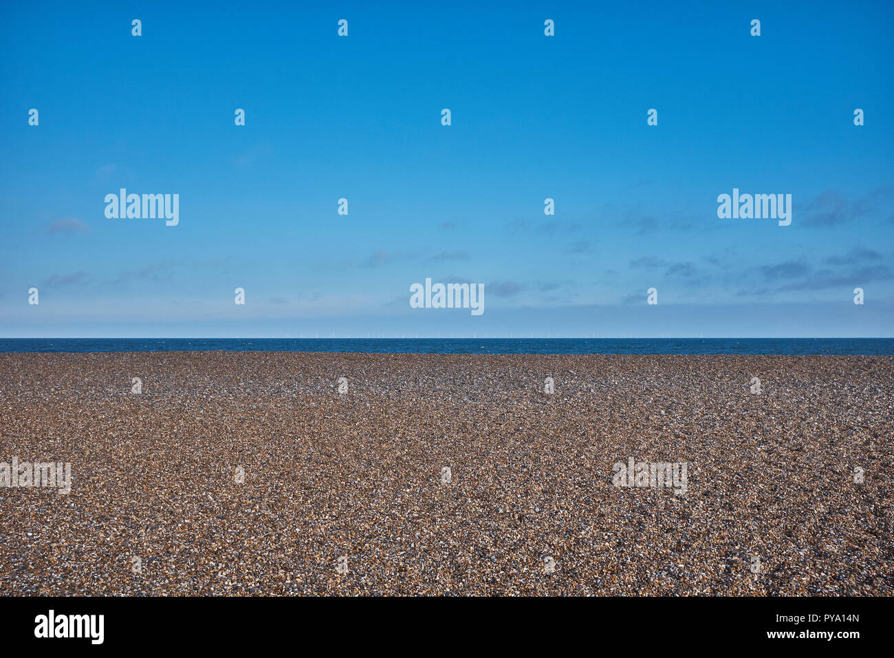 Playa de guijarros con ningún pueblo en la arcilla en el mar con gran cantidad de cielo azul y la pequeña cantidad de mar Foto de stock