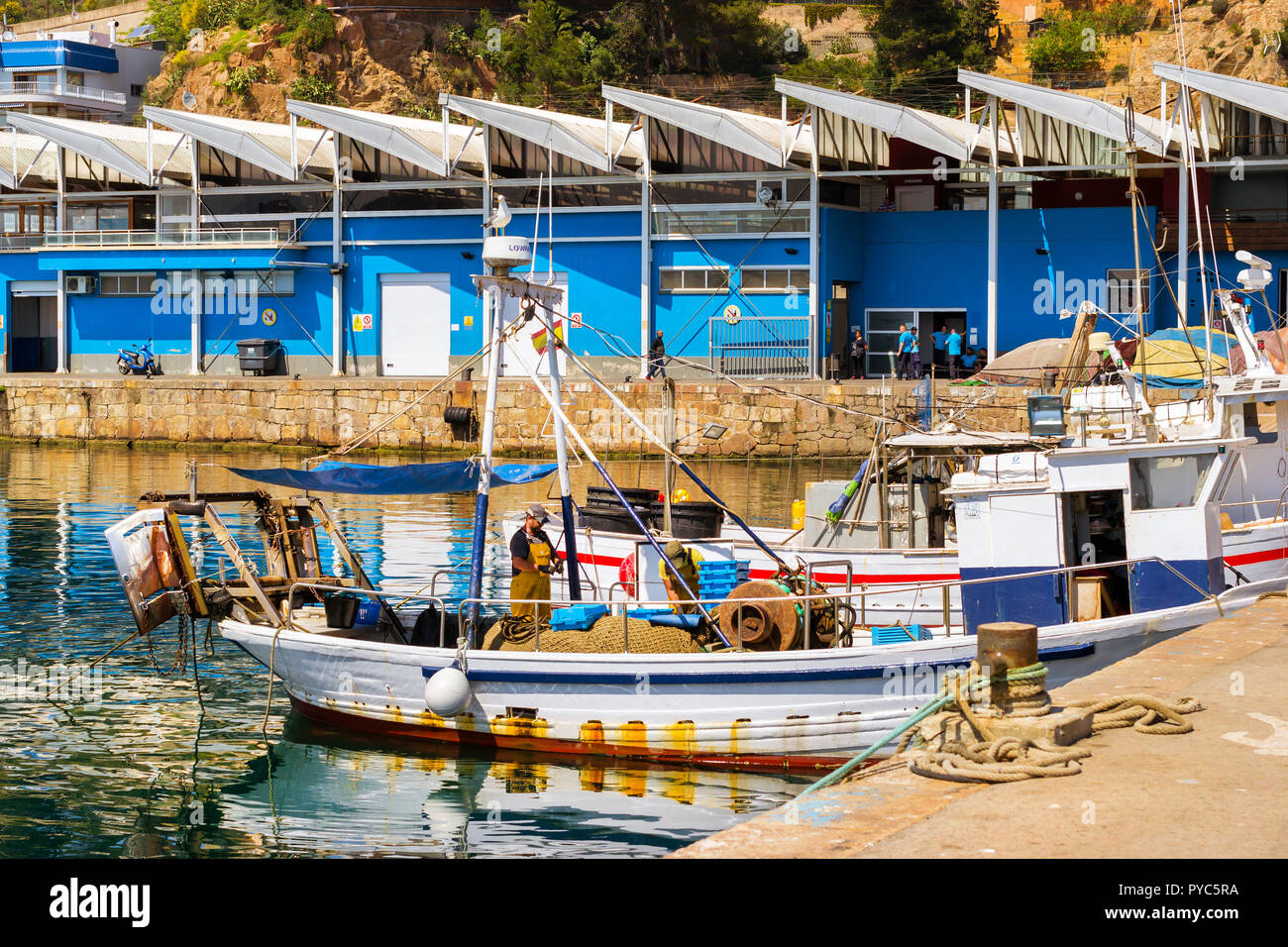 Blanes, España - 31 de mayo, 2018: los barcos de pesca y yates anclados en  el muelle en el puerto de Blanes. Los pescadores descargan la captura de  peces de mar, ostras,