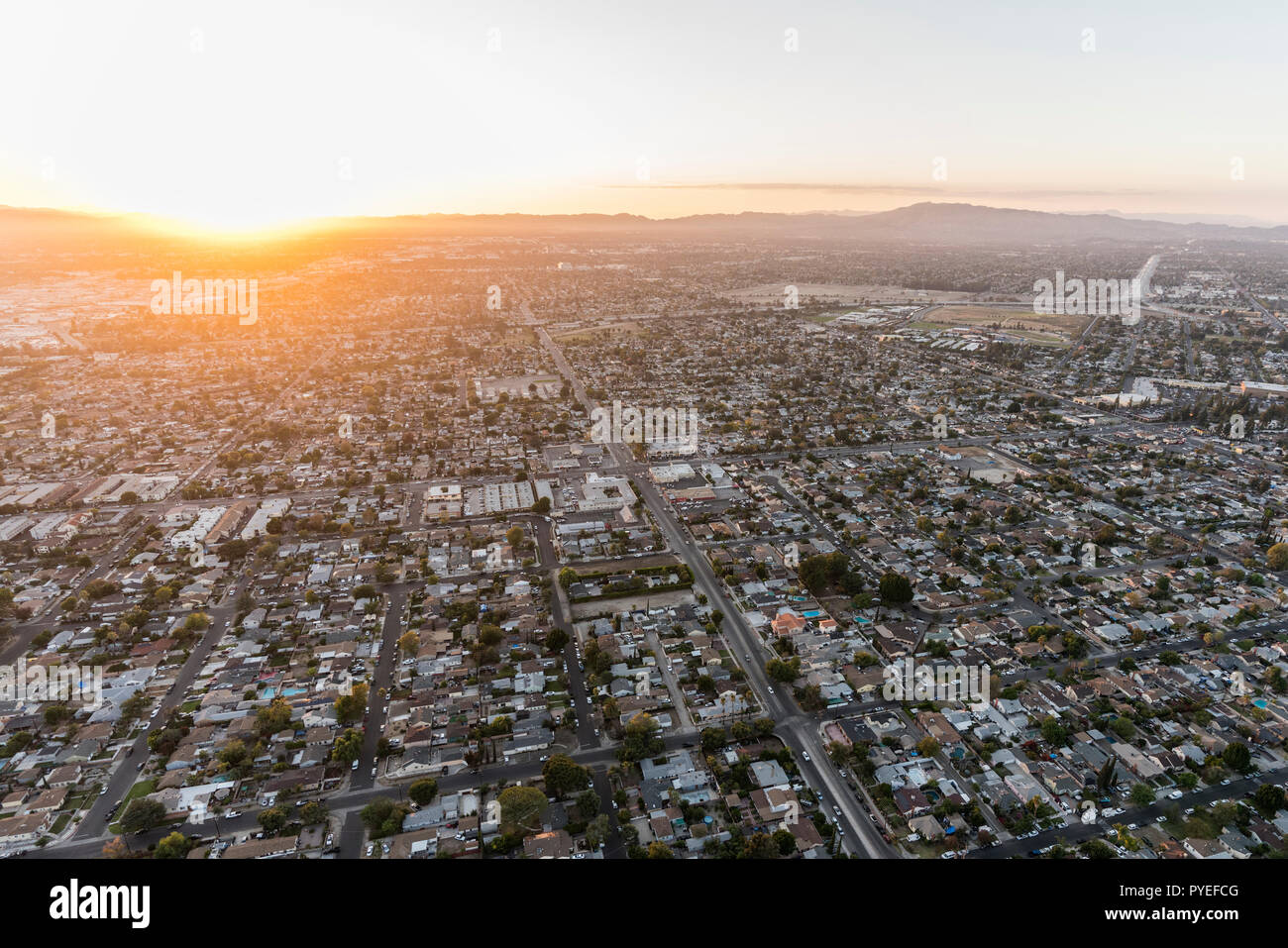 Puesta de sol vista aérea del Valle de San Fernando, casas y calles en Los Angeles, California. Foto de stock