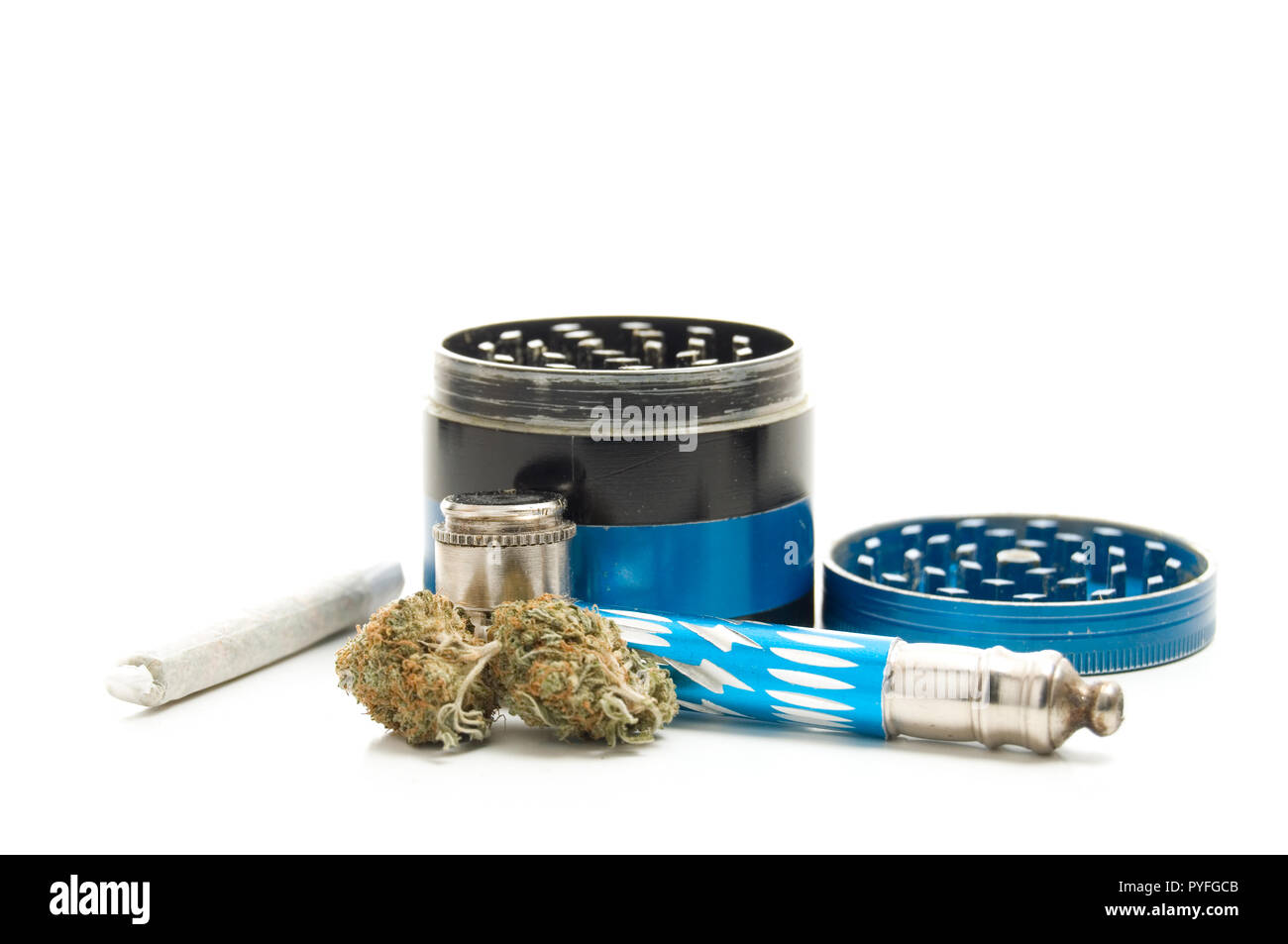 Brotes de cannabis, tubo, conjunta y muela sobre fondo blanco. Foto de stock