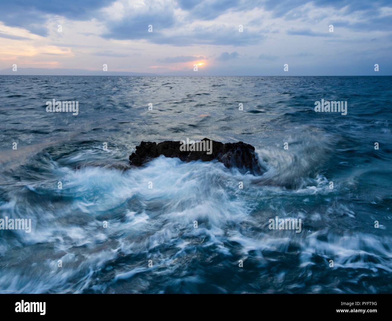 Las olas del mar golpeando dinámica rock mediados de larga exposición Foto de stock
