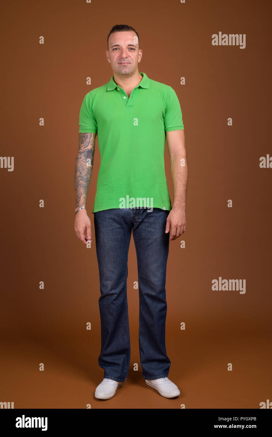 Una foto vertical de un atractivo hombre caucásico con mangas tatuadas  caminando durante el día Fotografía de stock - Alamy