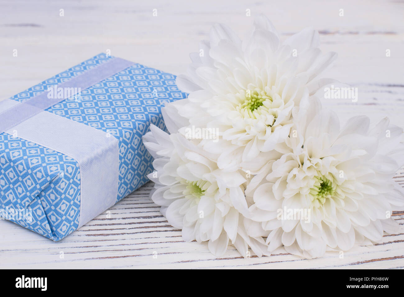 Elegante Caja de regalo y ramo de crisantemos blancos. Cuadro actual y  flores sobre fondo de madera cerca. Hermoso regalo para la novia Fotografía  de stock - Alamy