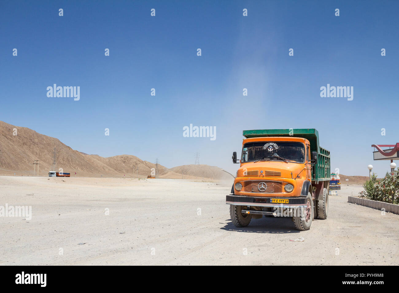 YAZD, Irán - Agosto 17, 2016: el viejo camión volquete iraní de pie sobre una autopista estacionamiento cerca de Yazd, en el medio del desierto, en la carretera que une Foto de stock