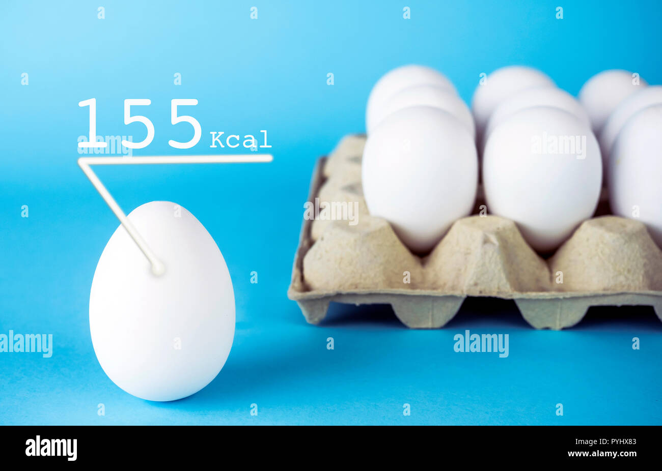 Los huevos de gallina blanca, 155 k calorías tiene un huevo, aislado sobre un fondo azul. Foto de stock